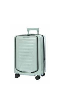 Valise rigide argentée avec poignée extensible et quatre roues pivotantes noires.