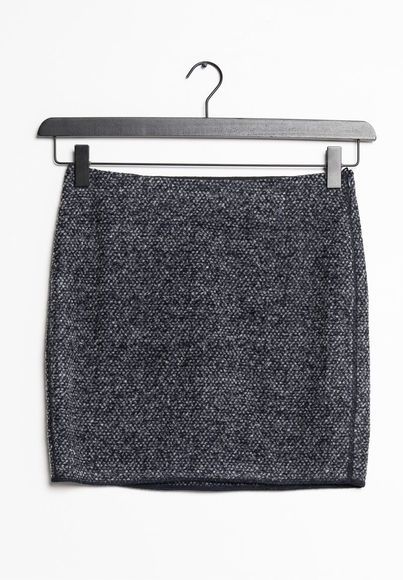 Mini-jupe en tweed gris foncé avec de subtils éclats blancs, suspendue à un cintre noir à pince sur fond blanc.