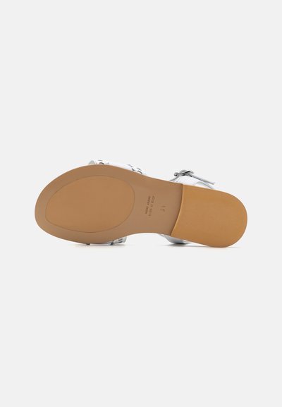 Sandal cu toc alb, cu o talpă netedă, curea ajustabilă și design minimalist. Talpa exterioară este de nuanță bej, cu o marcaj subtil și caracteristici.