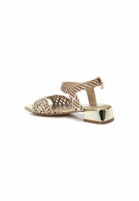 Sandalias metálicas trenzadas con tacón dorado y tira en el tobillo. Los colores incluyen dorado, blanco y marrón con un acabado texturizado.