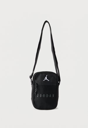Bolso bandolera negro Jordan con bolsillo frontal de malla, logo Jumpman blanco y correa de hombro ajustable.