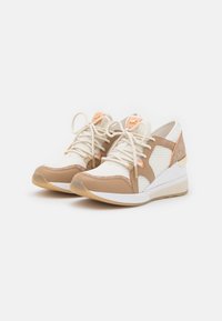 Scarpe da ginnastica beige e bianche con pannelli in rete, lacci crema e dettagli dorati. Hanno un tallone imbottito e una suola texturizzata.