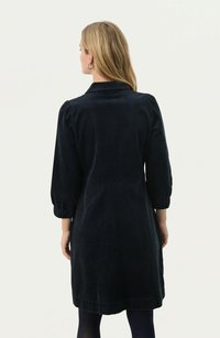 Vestito in corduroy nero con colletto, maniche a palloncino e orlo fino al ginocchio. Presenta una texture a coste verticali e una vestibilità morbida.