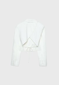 Chaqueta blanca corta con cuello de chal, mangas largas y un panel trasero oversize. Presenta un detalle de cordón en el dobladillo. Textura suave.
