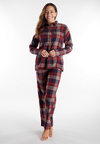 Rode en marineblauwe geruite pyjama met lange mouwen en knoopsluiting, met een losse pasvorm en bijpassende broek met elastische tailleband.