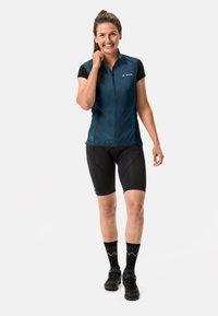 Korte ermer, glidelås foran sykkelvest i mørkeblå, sammen med svarte shorts. Har lettvektstoff og en tettsittende design med kontrastdetaljer.