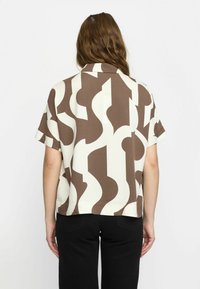 Short-sleeved shirt in a beige and brown abstract pattern, made of lightweight fabric, featuring a straight cut and a collar.