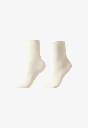 Cream-colored cotton socks with a smooth texture, featuring a ribbed cuff and standard ankle height. No visible patterns or logos.