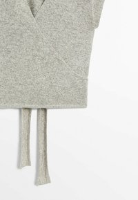 Vêtement en maille gris clair avec un design cache-cœur et deux longues lanières nouées suspendues au bord inférieur.