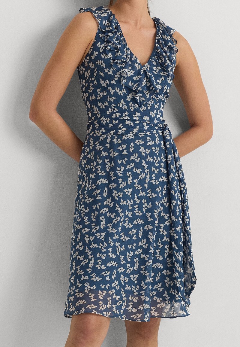 Blaues Blumenkleid mit Rüschenärmeln, V-Ausschnitt, Wickeldesign und einem fließenden Rock, aus leichtem Stoff mit kleinem weißem Blumenmuster.