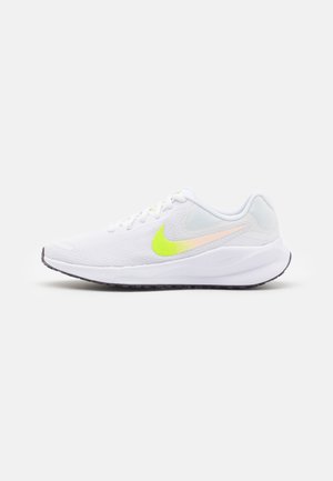 Biały nisko profilowy but do biegania z neonowo żółtym logo Nike i amortyzowaną podeszwą, pokazany z boku na jednolitym szarym tle.