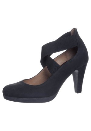 Sorte højhælede pumper lavet af nubuck med krydsede stofremme. Rund tå og spids hæl skaber et slankt, moderne design.