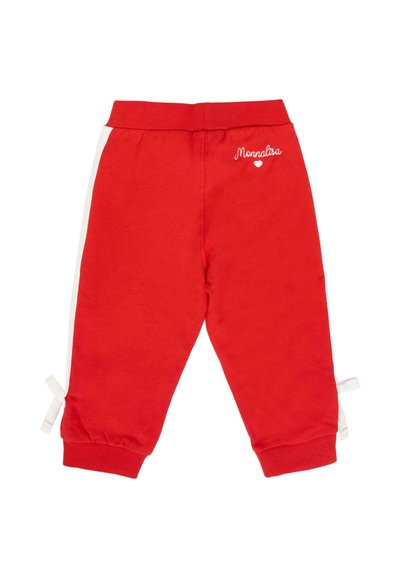 Pantaloni rossi per bambini con strisce laterali bianche, vita elasticizzata, polsini, fiocchetti vicino alle caviglie e "Monnalisa" ricamato con un cuore sopra.