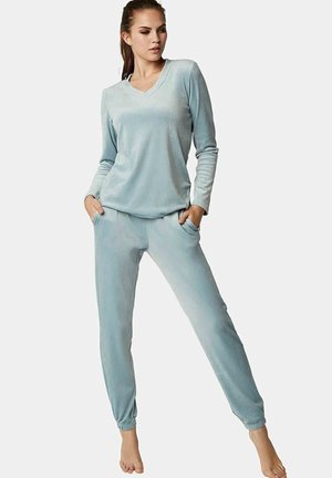 Ensemble de loungewear en tissu duveteux bleu clair comprenant un haut à manches longues en V et un pantalon à poignets élastiques avec des poches latérales.