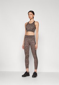 Dierlijke print sportset bestaande uit een cropped tanktop met een ronde halslijn en bijpassende high-waisted legging, beide in bruintinten.
