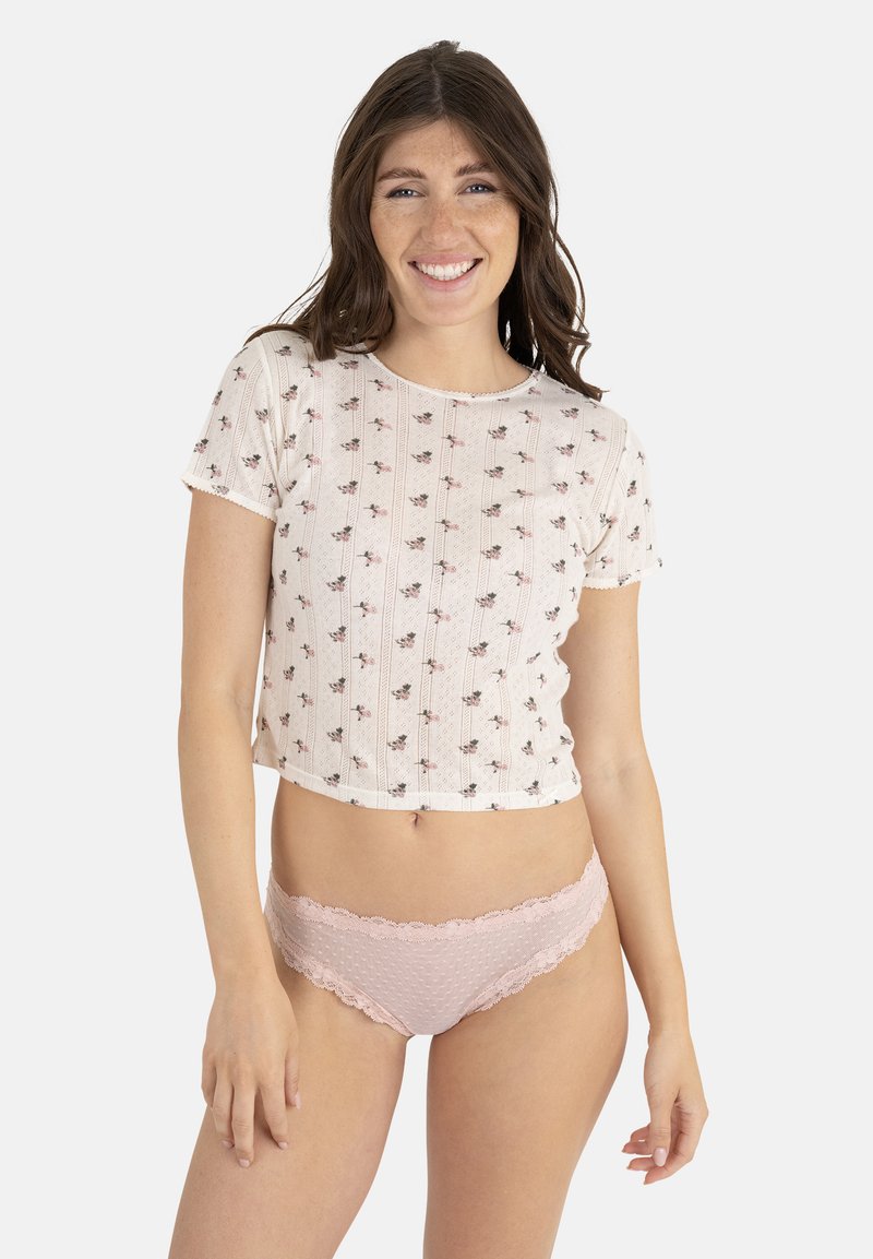 T-shirt en coton coupé avec un motif floral sur un fond clair, associé à des slips roses avec des bordures en dentelle affichant une texture à pois.