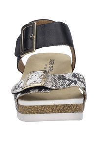 Czarne skórzane sandały na koturnie w wężowy wzór z szerokim paskiem, regulowanym zapięciem i korkową podeszwą, z brązowym wnętrzem i białą podeszwą.