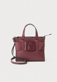 Sac à main en cuir bordeaux avec doubles poignées, bandoulière réglable et logo embossé à l'avant. Dispose de deux poches latérales et d'un design épuré.