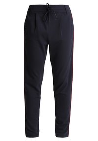 Pantalon de jogging bleu marine en tissu doux, avec taille à cordon, poches latérales et accents rouges sur les coutures latérales. Coupe ajustée.