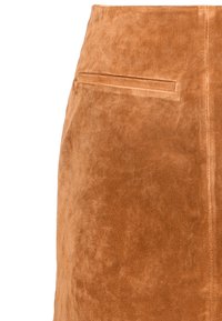 Vaaleanruskea mokkahame, jossa on pehmeä pinta. Siinä on yksi takatasku ja virtaviivainen muotoilu, joka luo istuvan siluetin.