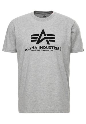 Pelēks kokvilnas T-krekls ar īsām piedurknēm, ar melnu logo "ALPHA INDUSTRIES", izcelsmes stils ar ģeometriskām akcentiem un pilsētas nosaukumu.
