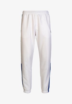 Weiße Sporthose mit blauen Seitenstreifen, elastischem Bund und schmal zulaufenden Säumen. Hergestellt aus leichtem, atmungsaktivem Stoff mit einer strukturierten Oberfläche.