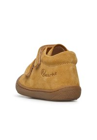 Stivale alla caviglia in camoscio giallo con punta tonda, fascia in Velcro, suola in gomma beige, logo del marchio impresso e dettagli testurizzati sul tallone.