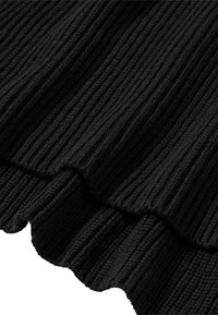 Tela de punto negro con borde con volantes, que muestra textura y profundidad a través de líneas verticales y hilados gruesos y suaves.