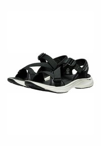 Chanclas negras de exterior con correas ajustables, parte superior de textil, entresuela blanca y suela exterior de goma negra texturizada.