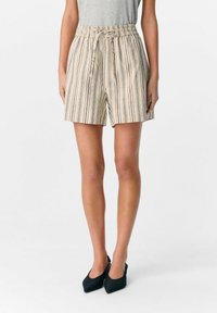 Beige randiga shorts med elastisk midja och dragsko. Tillverkade av ett lätt tyg, med vertikala blå och bruna ränder.