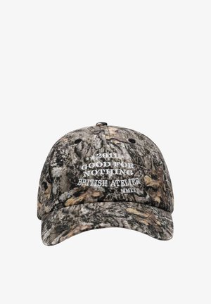 Baseballpet met camouflagepatroon en witte geborduurde tekst aan de voorkant die "2011 Good For Nothing British Atelier MMXI" aangeeft.