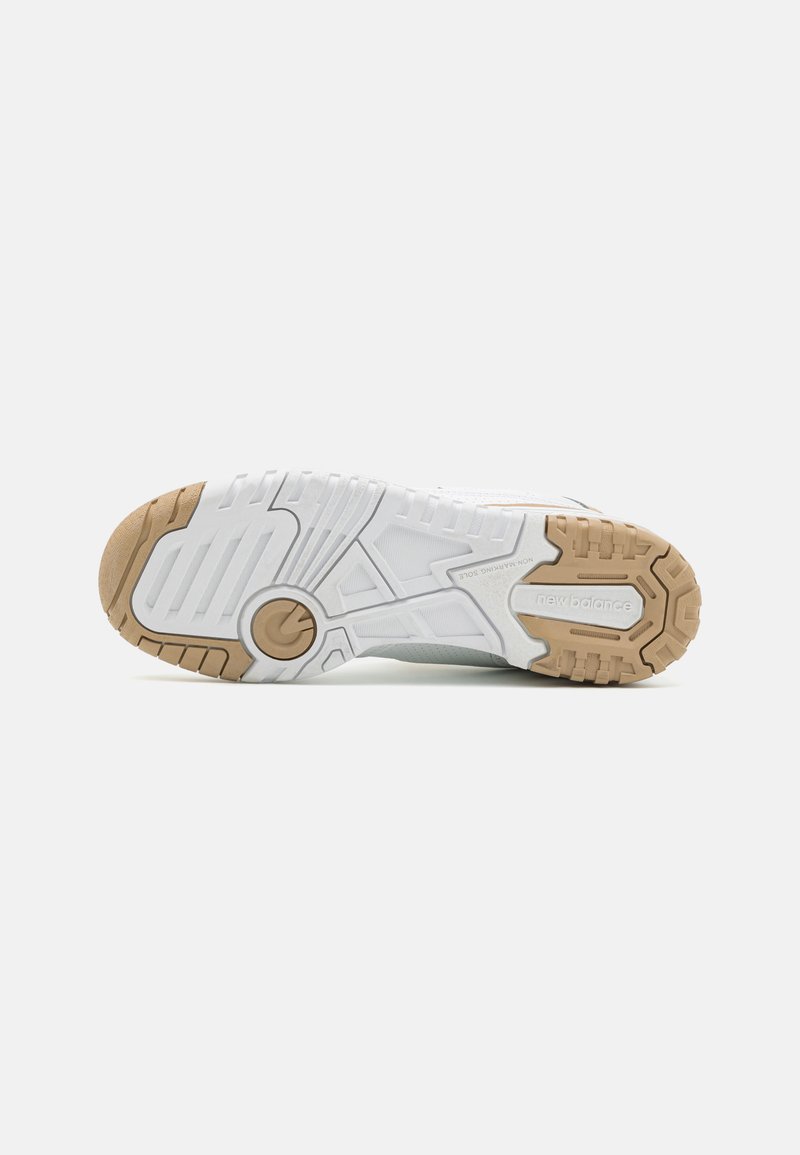 Semelle d'une chaussure de sport blanche avec une surface en caoutchouc texturée, présentant une accentuation brune et un logo bien visible au niveau du talon.