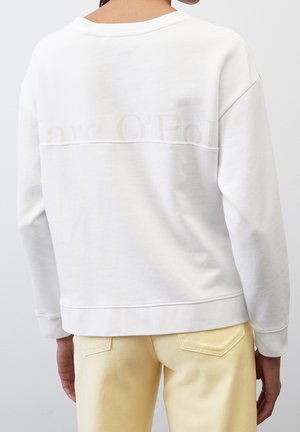 Sweatshirt blanc avec une coupe décontractée, un col arrondi et des manches longues. Présente un logo discret à l'arrière et des détails de bord côte.