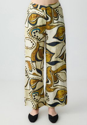 Pantalons larges en tissu léger, avec une base crème ornée de motifs abstraits bruns, bleus et noirs, et une fermeture par bouton.