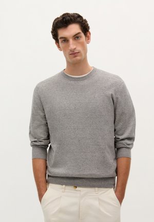 Maglione grigio a maglia con scollatura rotonda, polsini e orlo a coste. Il tessuto mostra una leggera texture con leggere variazioni di colore.