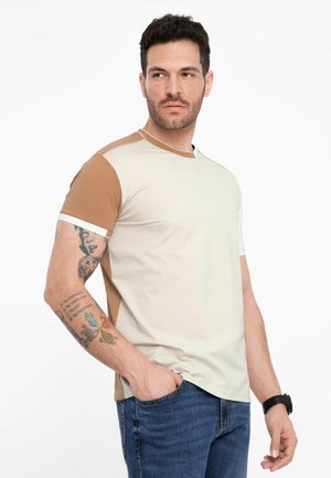 Kortærmet, farveblokkeret t-shirt i lys beige, brun og hvid. Lavet af glat stof, har kontrasterende skulderpaneler.