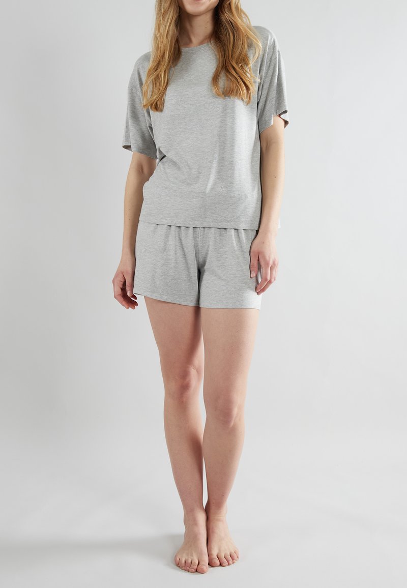 T-shirt grigio a maniche corte con vestibilità rilassata, abbinato a pantaloni corti grigi coordinate. Tessuto morbido, design semplice, senza motivi.