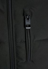 Schwarze Daunenjacke aus Stoff mit einem sichtbaren Reißverschluss auf der Vorderseite. Merkmale sind ein elegantes Design und eine glatte Textur mit Steppnähten.