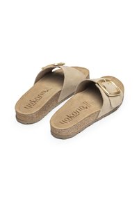Tan suede slide sandals with a wide strap and gold buckle detail, on a textured cork base. Lightweight and open-toed design.
