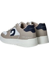Zapatillas beige y navy con un acento blanco. Fabricadas en cuero suave, con una suela gruesa, detalle del logo y acentos cosidos.