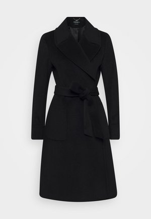 Manteau en laine noir longueur genou avec larges revers, manches longues, poches plaquées et ceinture en tissu nouée à la taille.