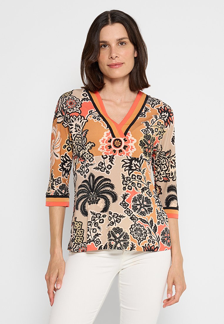 Bloemendruk top met V-hals en driekwartmouwen. Bevat oranje, zwart en beige kleuren met decoratieve accenten en patronen.