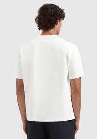 Witte t-shirt met korte mouwen, gemaakt van zachte stof, met een ronde halslijn en een ontspannen pasvorm, een gladde textuur en een eenvoudig ontwerp.