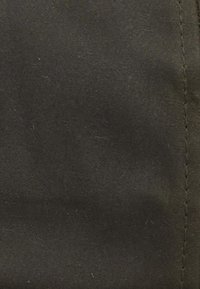 Tecido verde escuro com uma textura suave e um brilho subtil, apresentando costuras visíveis e sem padrões ou embelezamentos distintos.