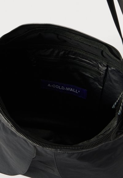 Schultertasche aus schwarzem Nylon mit einem Innenfutter, das eine Reißverschlusstasche und ein mit "A-COLD-WALL*" beschriftetes Etikett enthält. Glatte Textur mit minimalistischem Design.