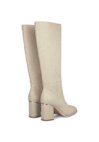 Cizme bej din piele până la genunchi, cu vârf pătrat și toc gros cu accente argintii. Textură netedă, cu detalii minime de cusătură.