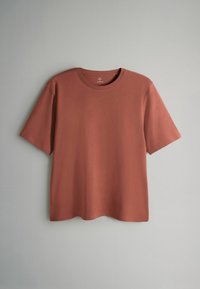 Kortärmad t-shirt med rund hals i rostfärg, tillverkad av slät tyg, med en avslappnad passform och utan synliga mönster eller detaljer.