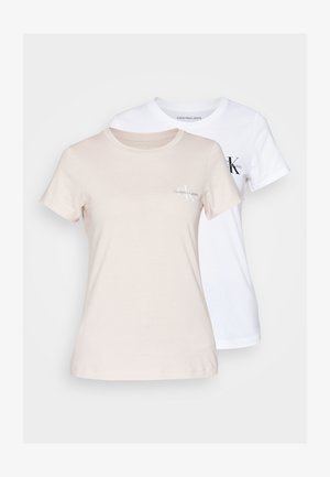 Kaks lühikeste varrukatega t-särki, üks heledas beezis ja teine valges, valmistatud puuvillast, väikese logoga rinnapiirkonnas.