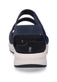 Námořnické modré sandály s více popruhy, měkkou semišovou strukturou, polstrovanou stélkou a bílou a černou gumovou podrážkou pro stabilitu.