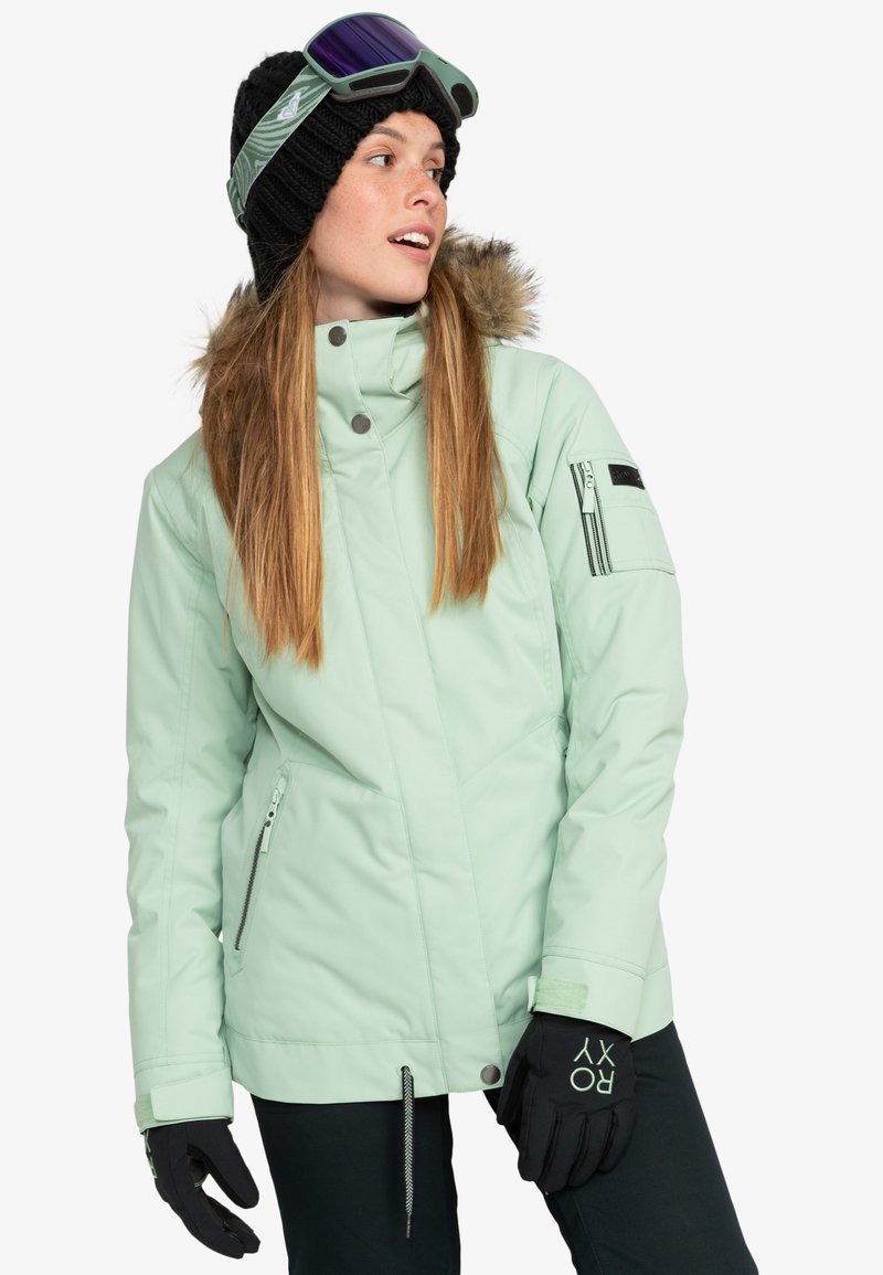Mint green ski jacket with a faux fur collar, zippered pockets, and a sleek design, paired with black gloves featuring textured accents.